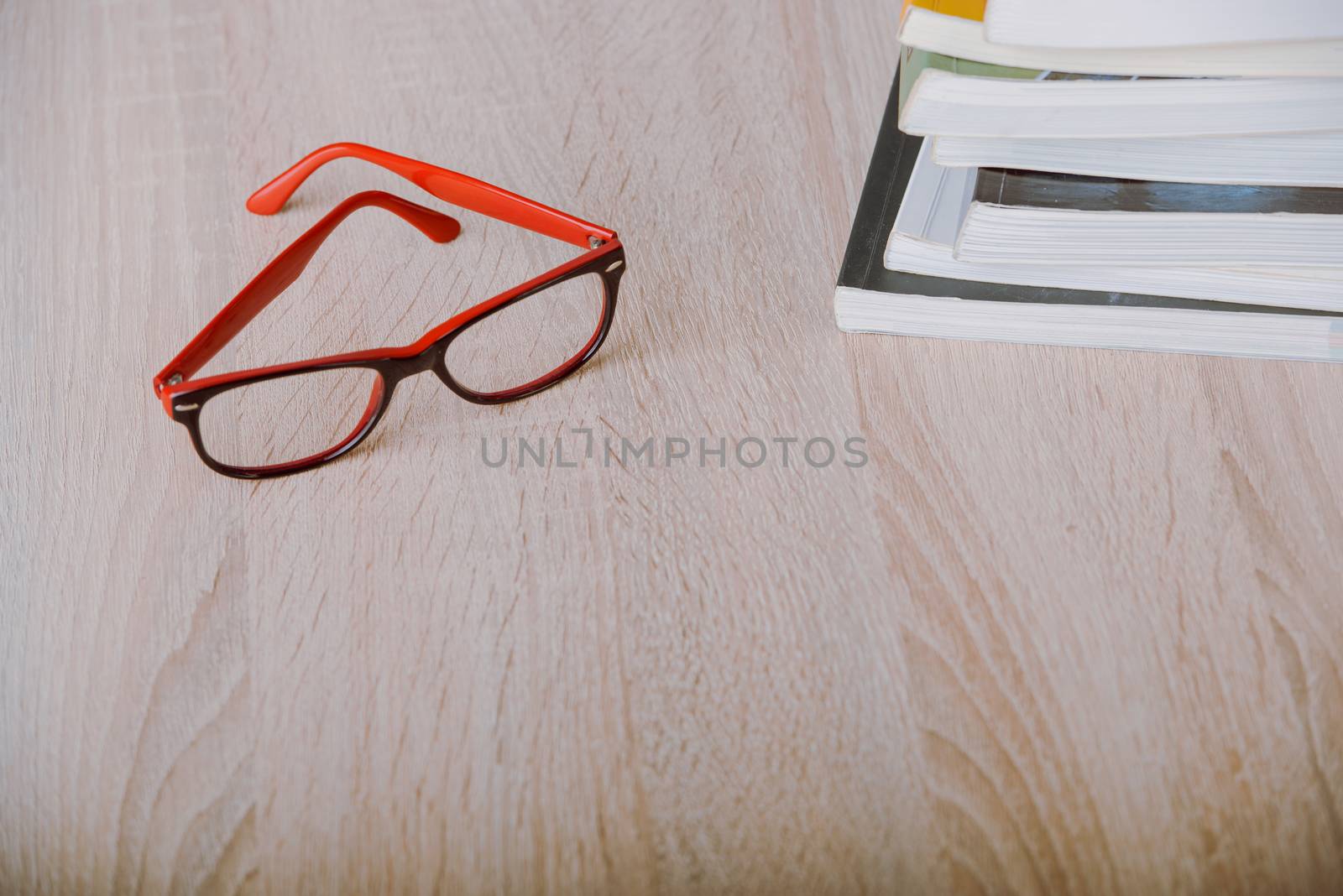 book and eyeglasses on wood background desk