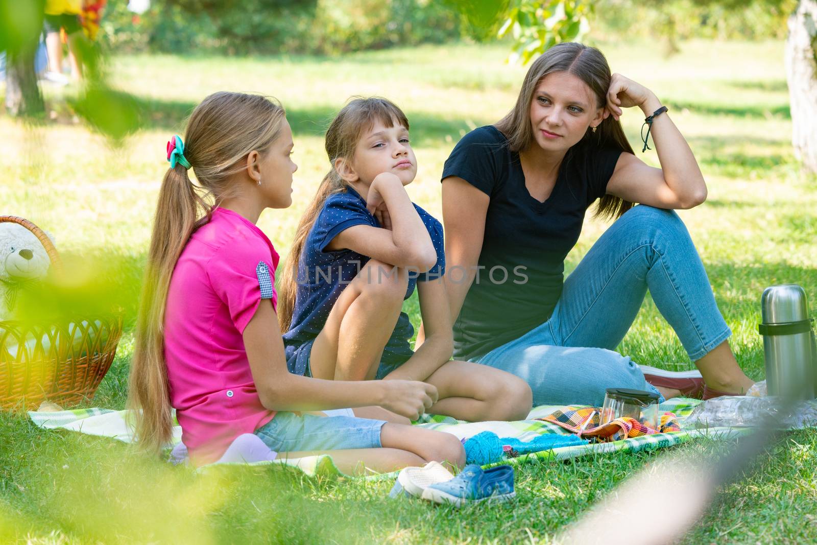 Sisters of different ages talking cute on a picnic