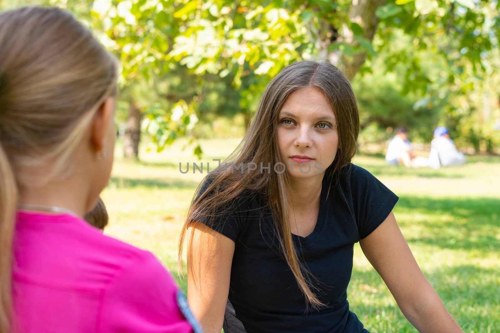 The girl on a picnic listens attentively to the interlocutor