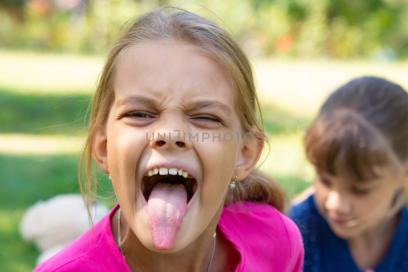 The girl turned and funny shows a long tongue