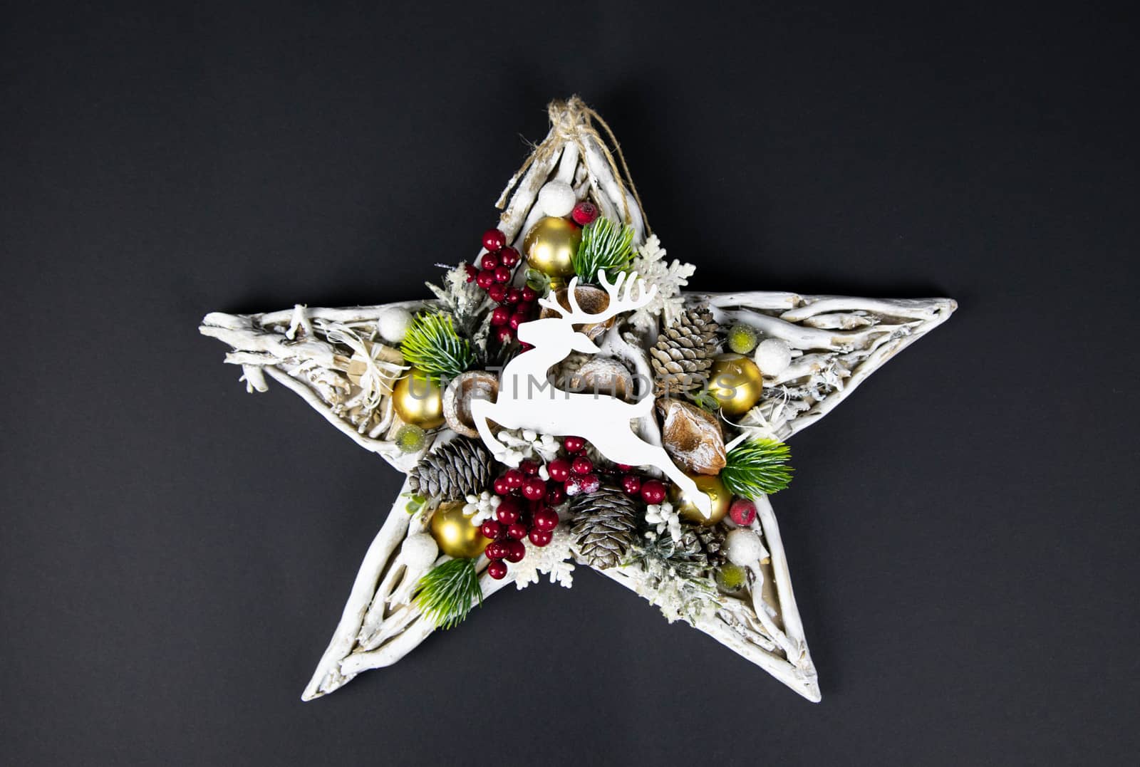 Handmade star decorated with cones and cranberries with christmas deer