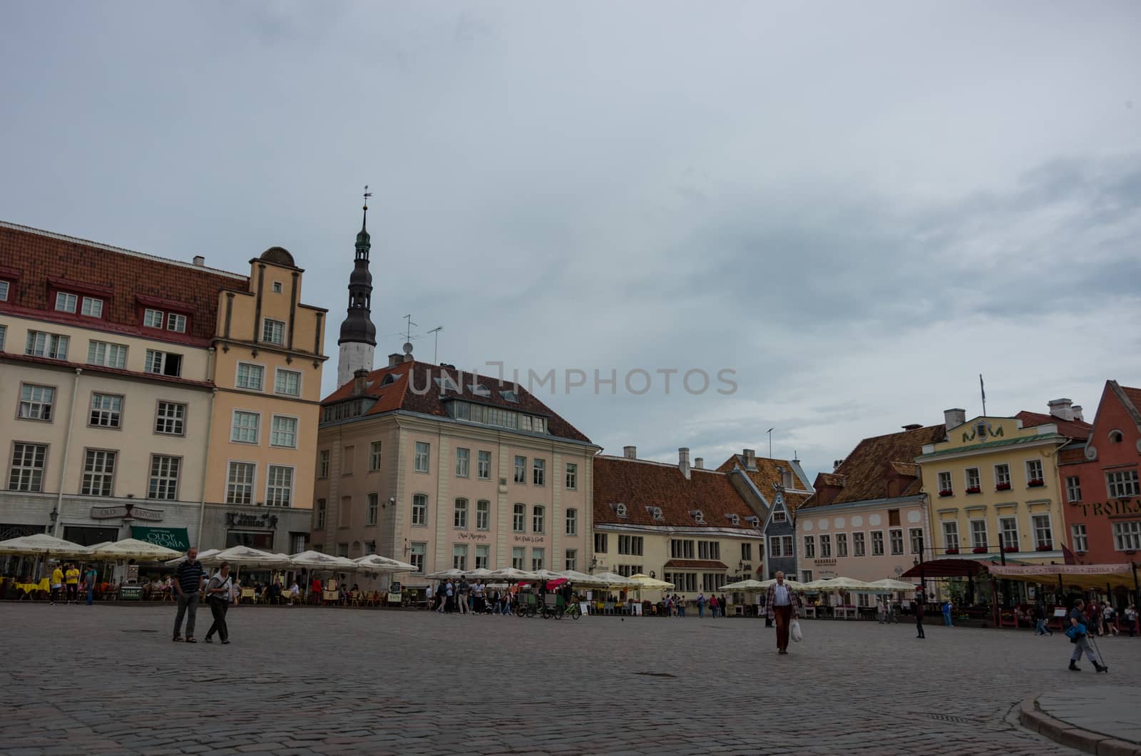 Tallinn, Estonia - July 29, 2017:  Tourists crowd the sidewalk cafes and shops in the medieval Tallinn Town Square in the walled city of Tallinn Estonia.