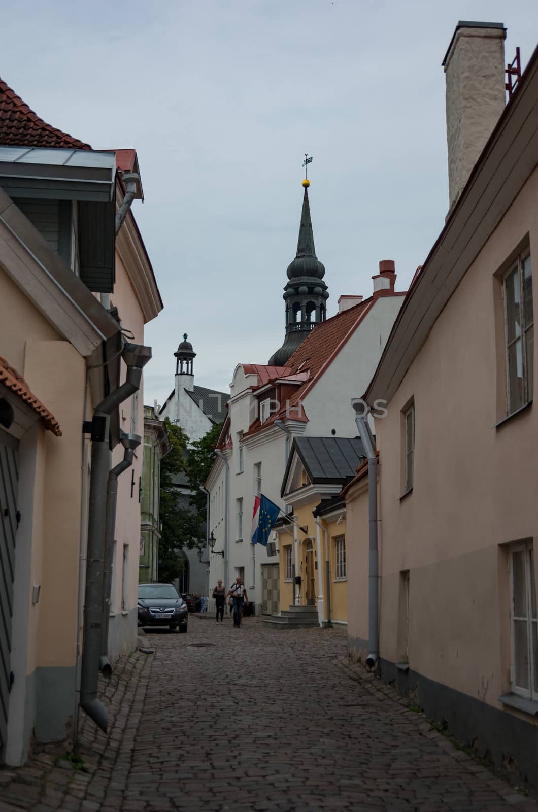 Tallinn, Estonia - July 29, 2017: Narrow street in the old town on Toompea Hill of Tallinn with St Mary's Cathedral (Dome Church) at background, Estonia