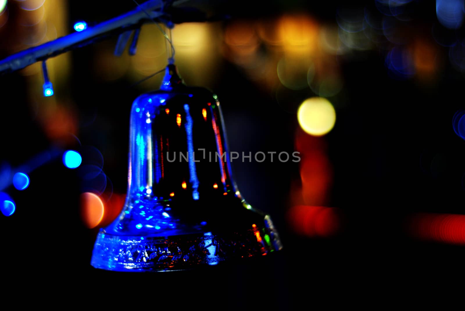 Blurred Christmas lights in the night with a bell on a black background, bokeh, Light bokeh abstract.