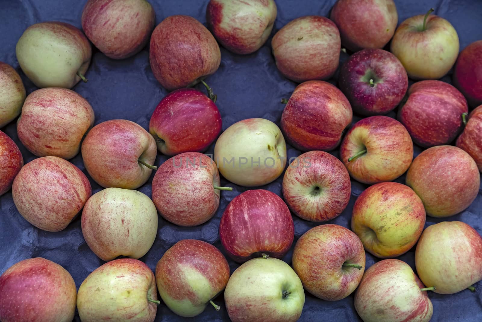 Seasonal fruits are placed in boxes in the grocery store. Close-up of fresh delicious apples. Natural foods rich in vitamins for a healthy diet.