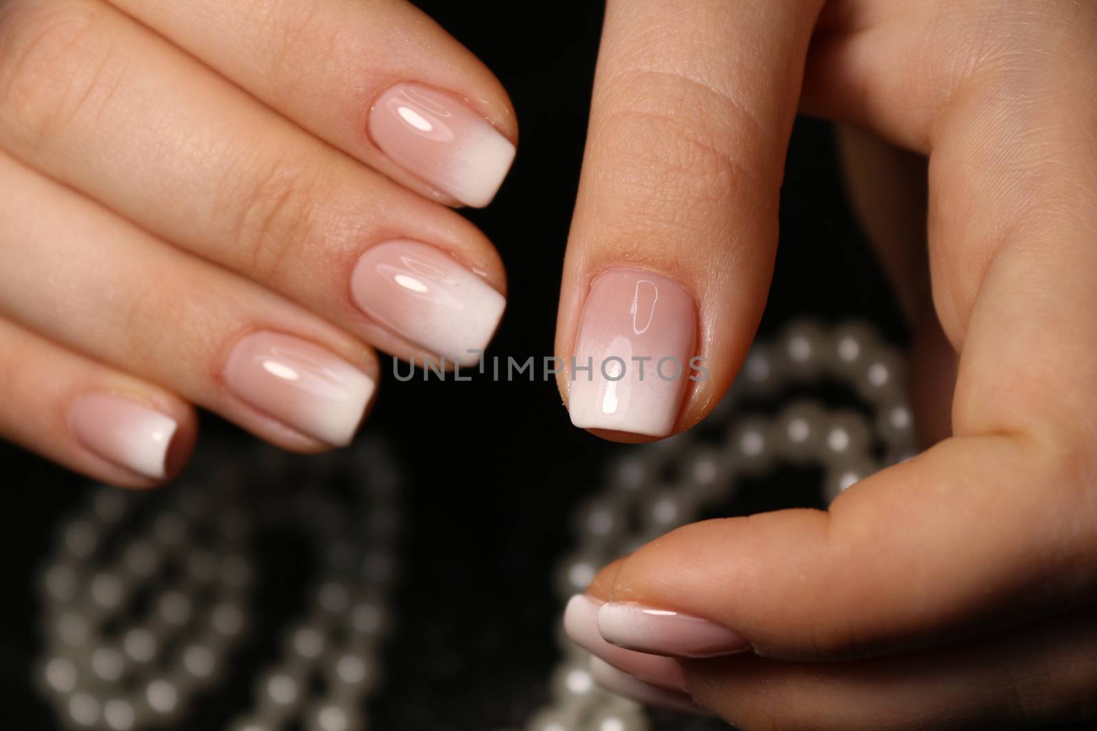 Closeup photo of a beautiful female hands with elegant manicure and diamond rings.