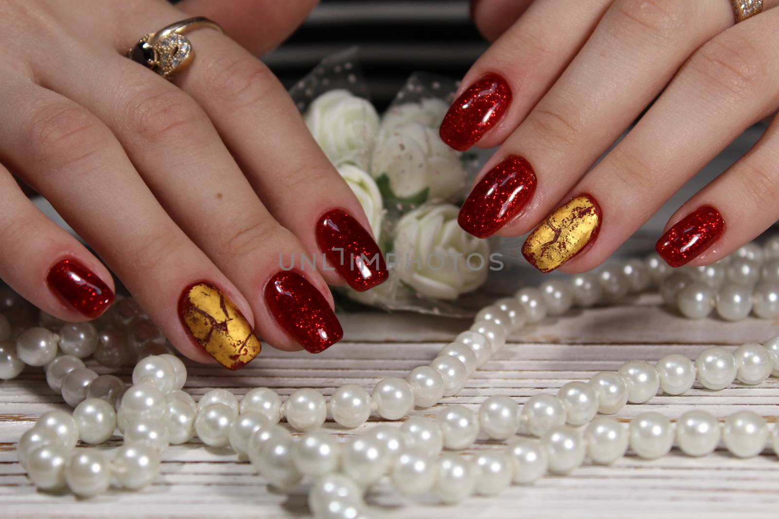 Hands with long artificial manicured nails colored with red nail polish