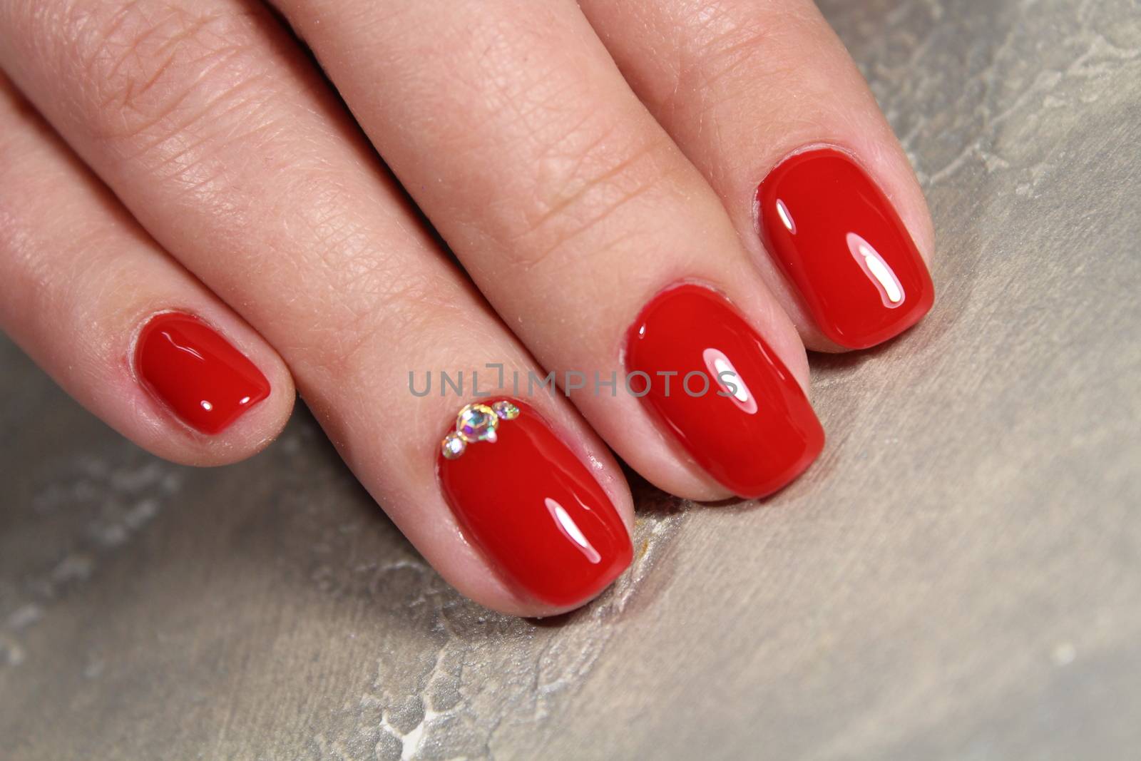 Manicured nails colored with red nail polish by SmirMaxStock