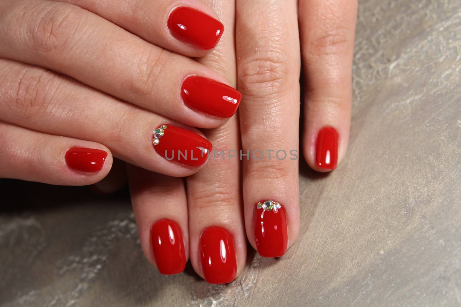 Manicured nails colored with red nail polish by SmirMaxStock