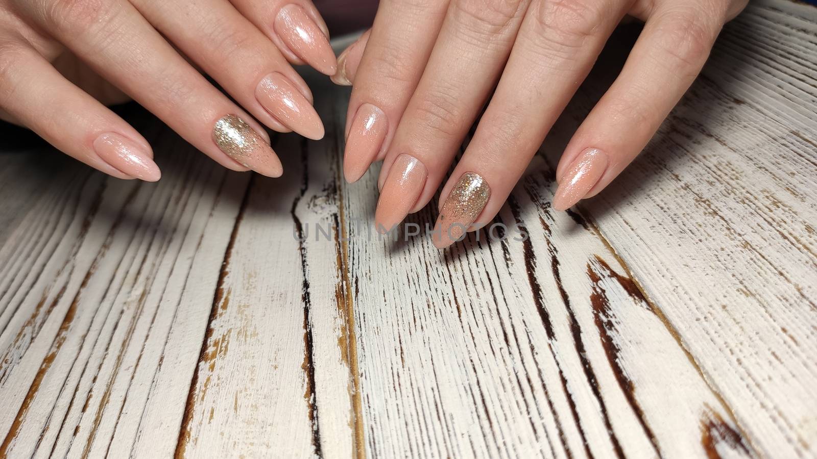 Glamorous luxurious brown crocodile manicure with gold plated women's nails closeup.