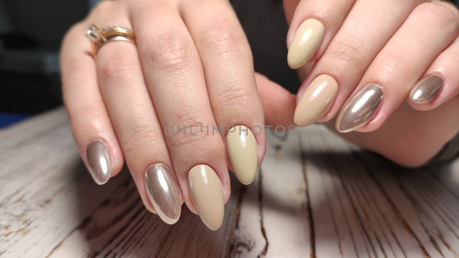 Glamorous luxurious brown crocodile manicure with gold plated women's nails closeup.