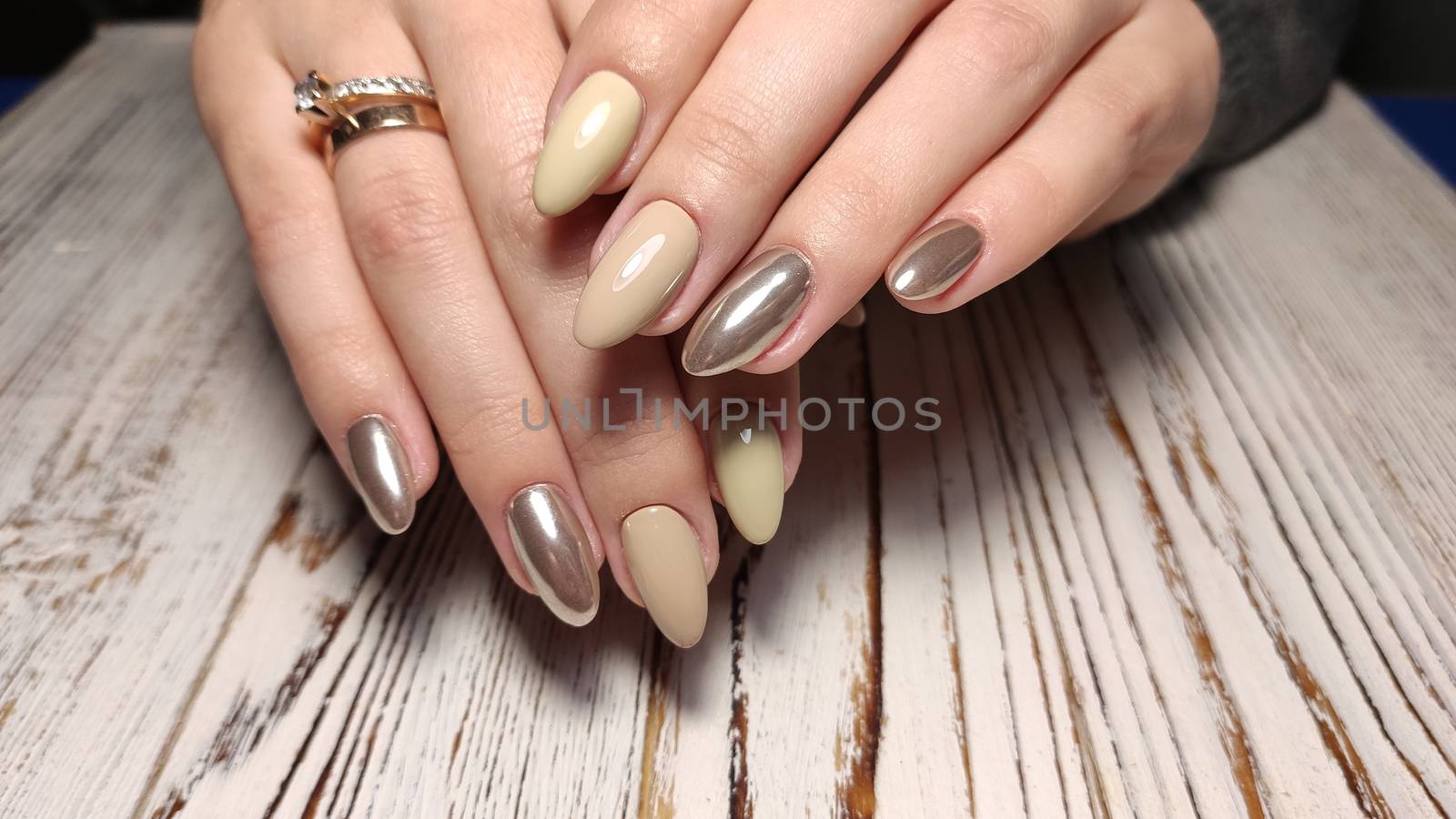 Glamorous luxurious brown crocodile manicure with gold plated women's nails closeup.