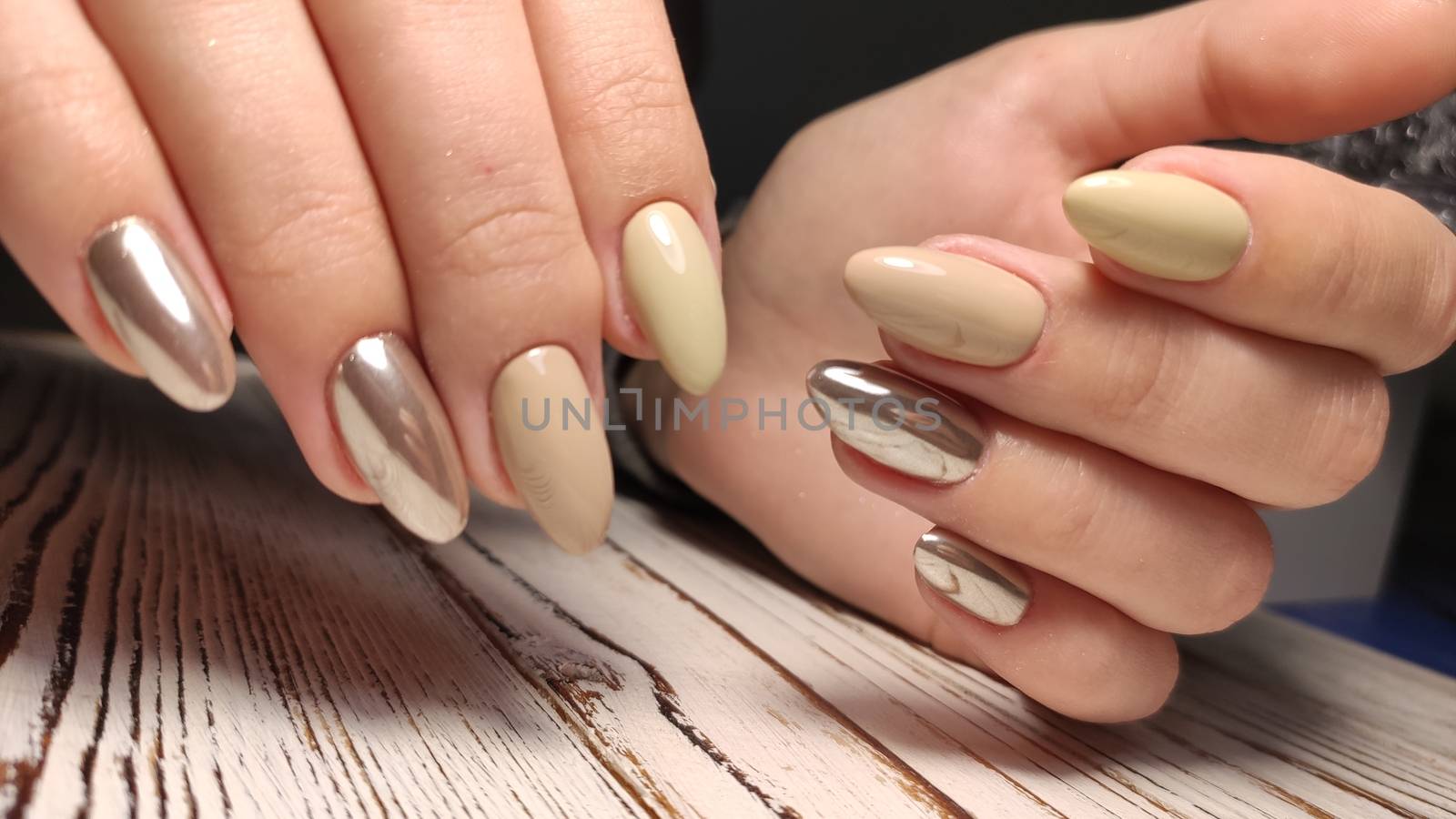 Glamorous luxurious brown crocodile manicure with gold plated women's nails closeup.