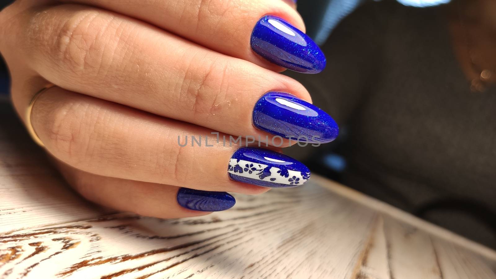 Hands with long artificial manicured nails colored with red nail polish