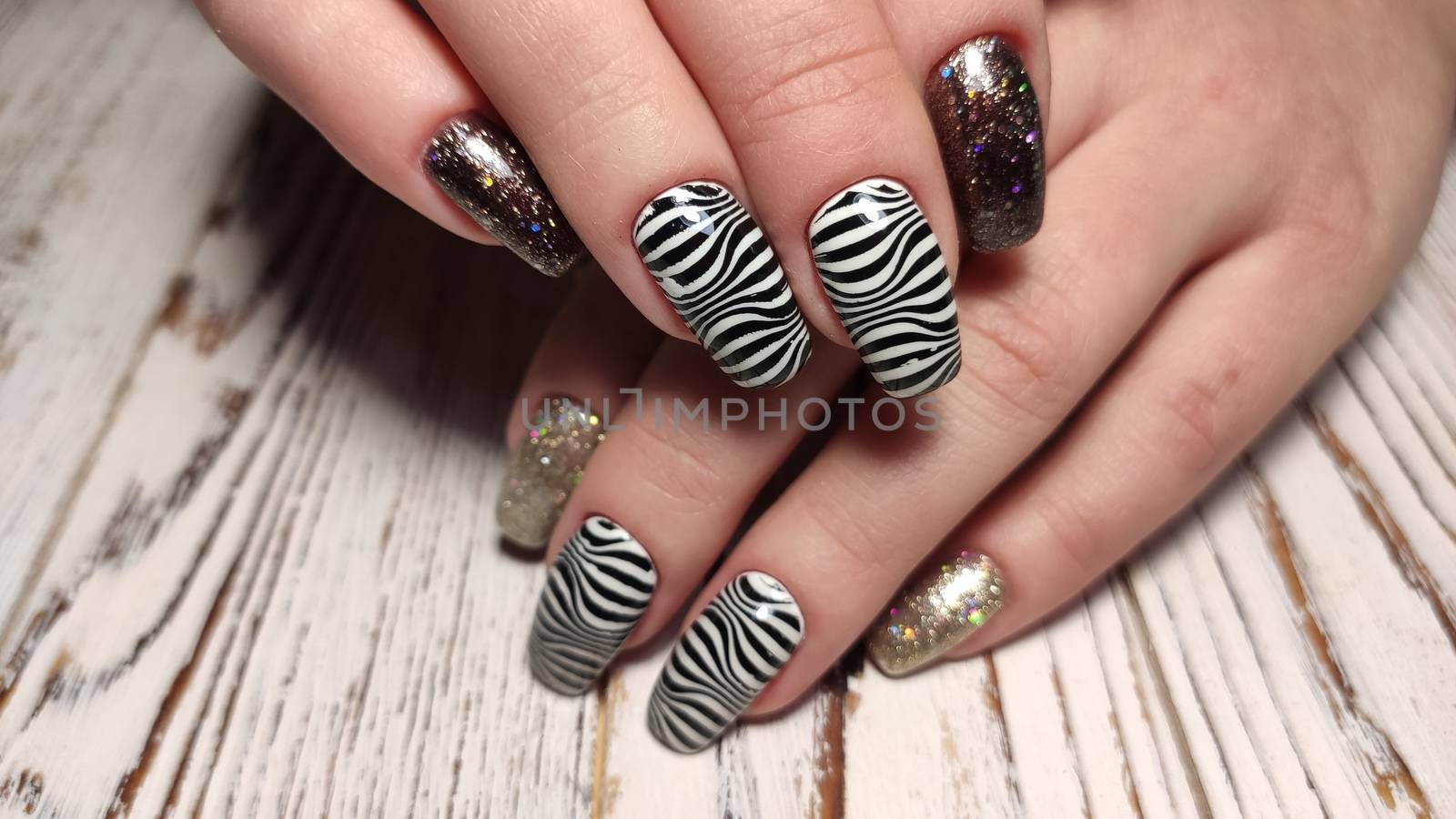 Hands with long artificial manicured nails colored with red nail polish