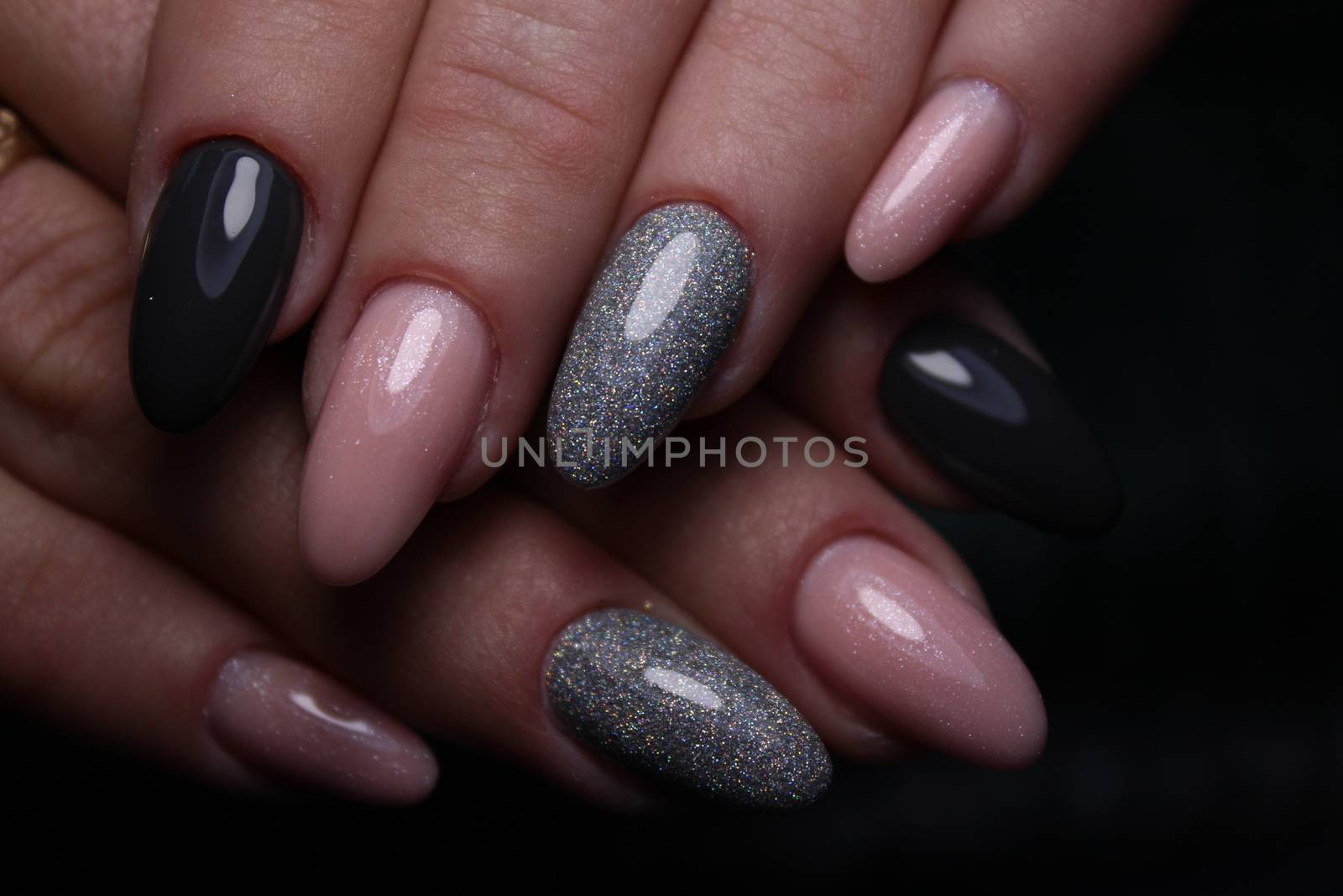 Closeup of hands of a young woman with dark red manicure on nails against white background