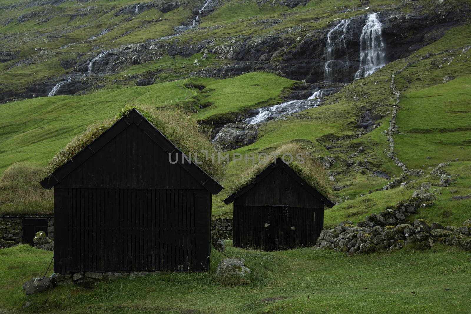 Saksun, Faroe Island - 18 September: Landscape showing a typical hut with grass roof and waterfall