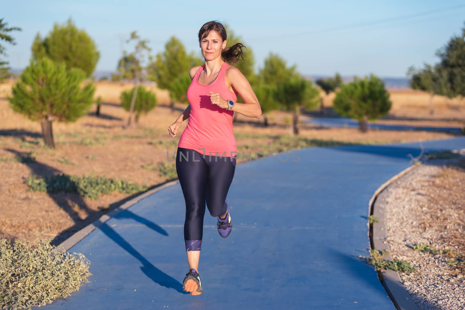 Fitness woman running in the park by HERRAEZ