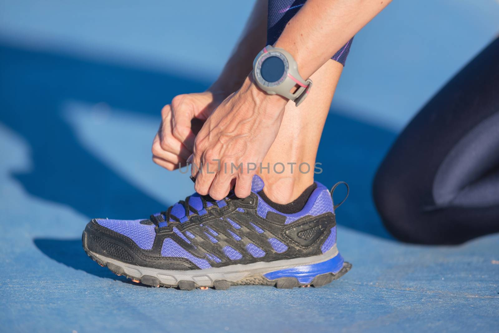 closeup of woman tying shoe laces. Female sport fitness runner getting ready for jogging outdoors