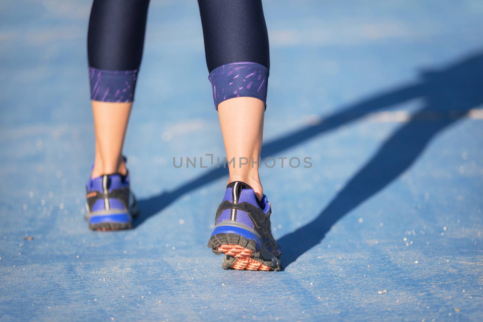 Runner feet running closeup on shoe. woman fitness jog workout welness concept. by HERRAEZ