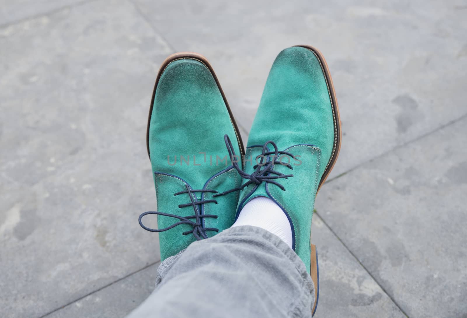 man with modern green shoes with stone terrace background