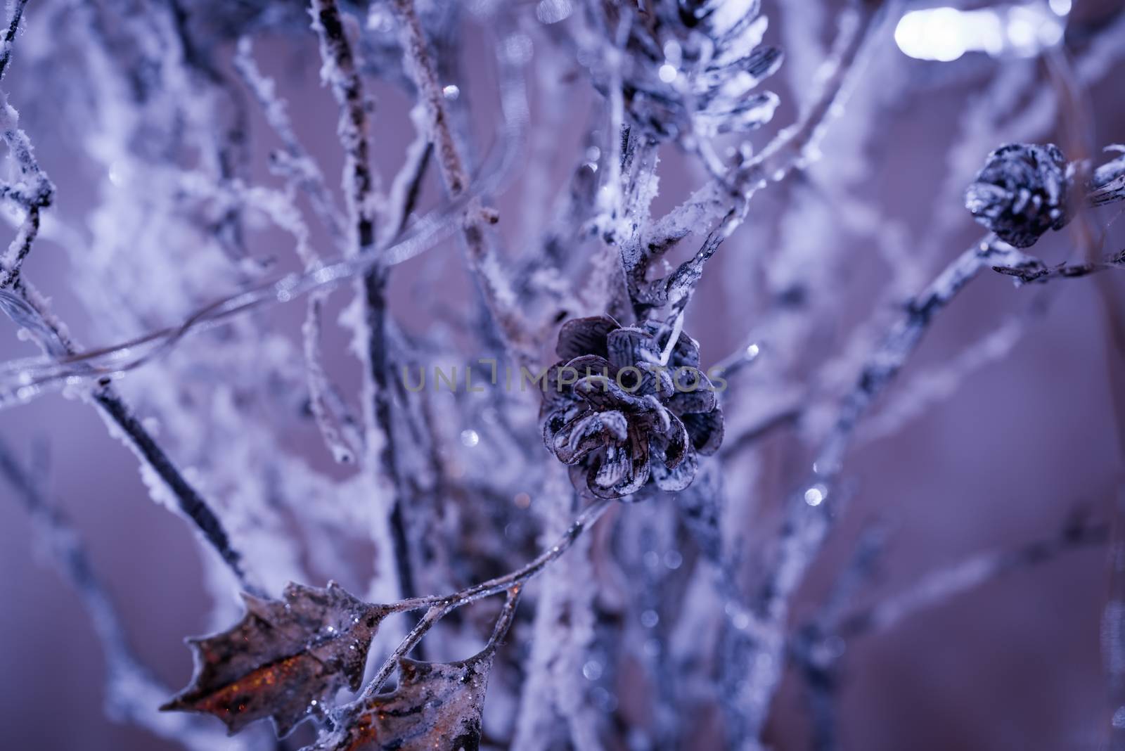 Christmas decoration hanging on a tree covered with snow. Focus on a decoration.