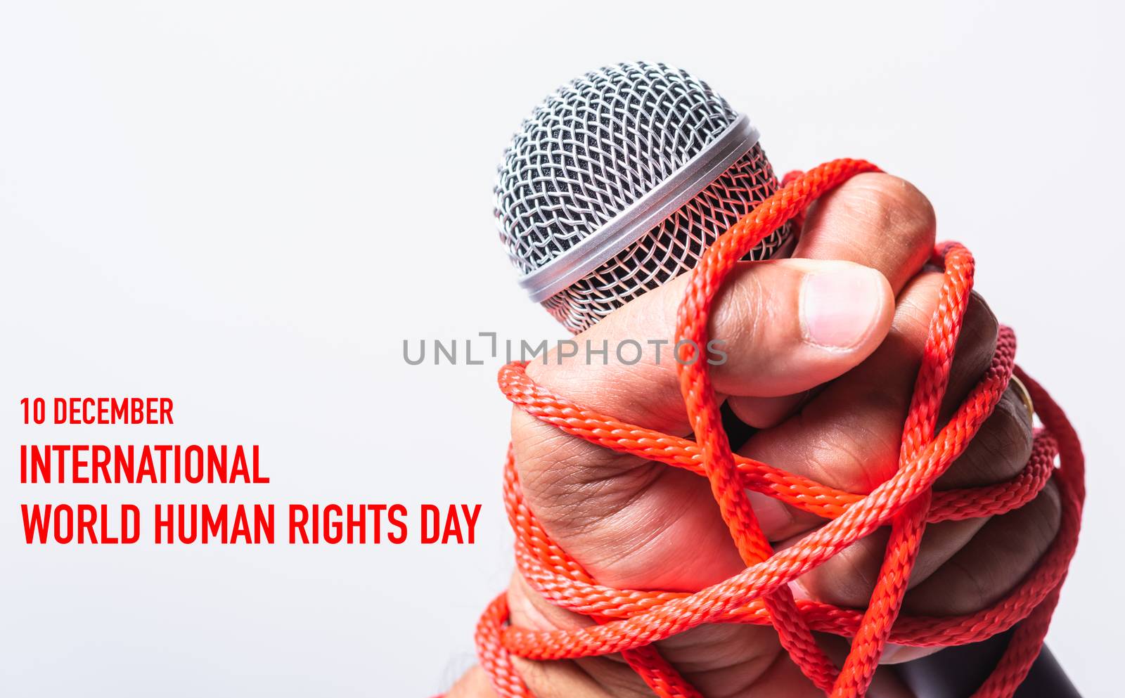 Hand holding microphone and have roped on fist hand with 10 december international HUMAN RIGHTS DAY text on white background, Human rights day concept