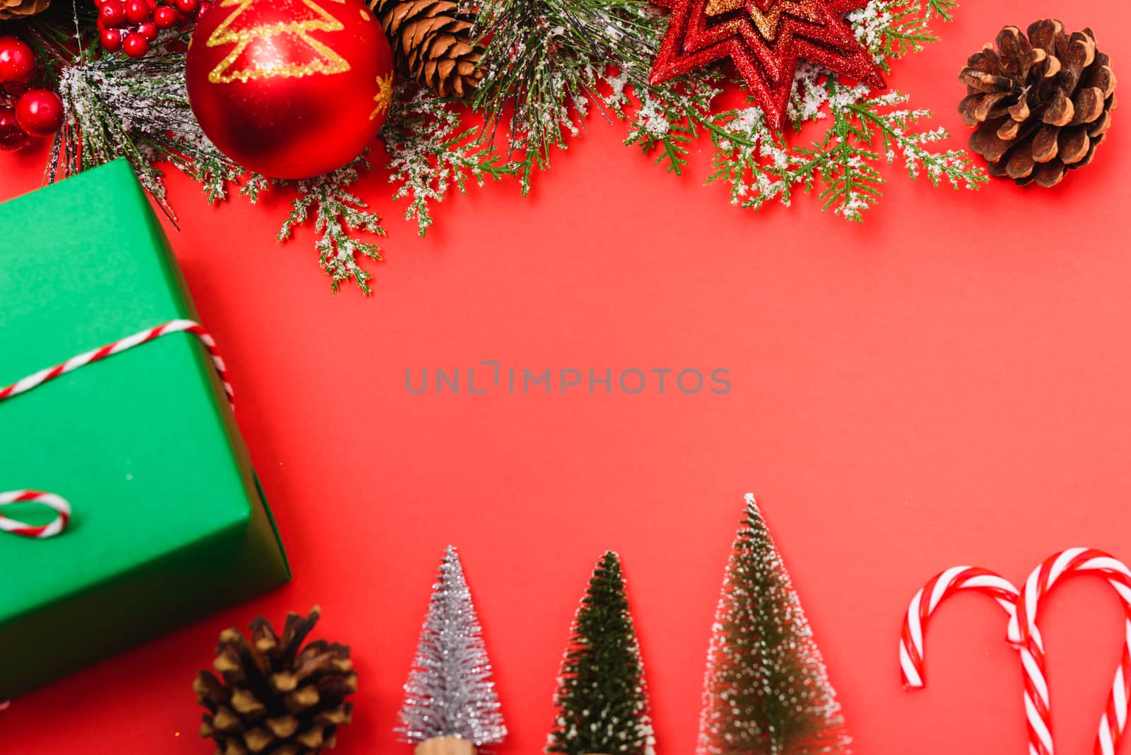 Christmas green gift box and decorations, fir tree branches on red background. Merry Christmas concept. With Copy space for text