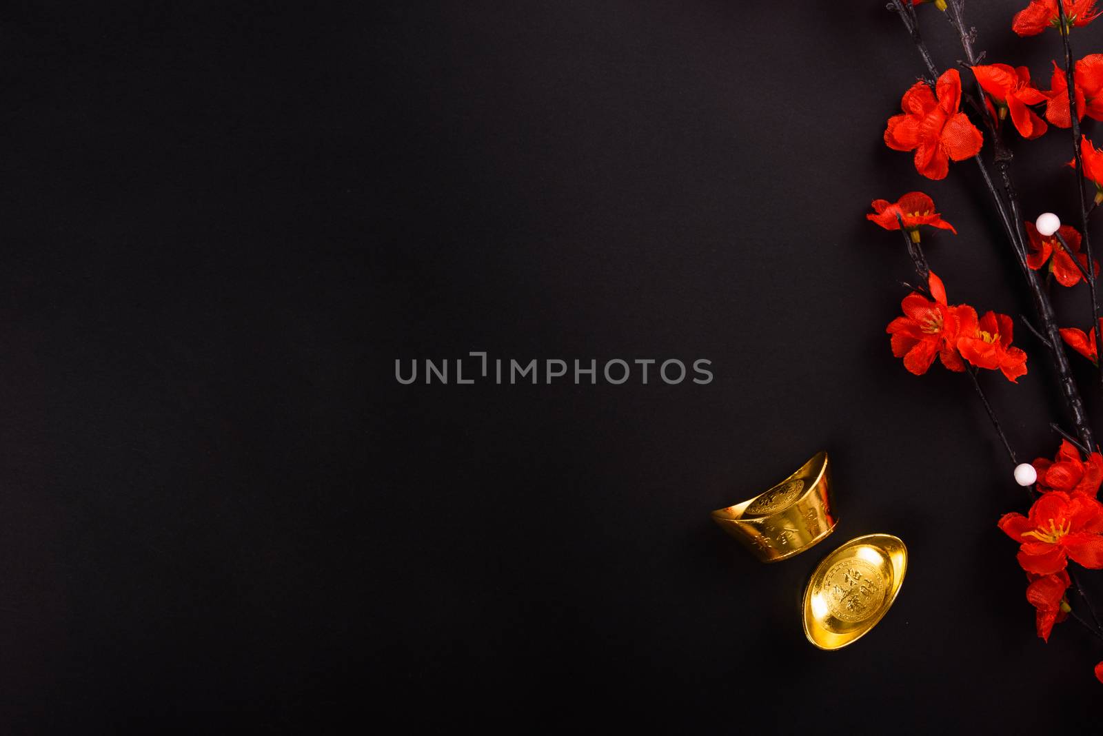 Chinese New Year, flat lay top view, gold bar and Chinese Flower on black background with copy space for your text
