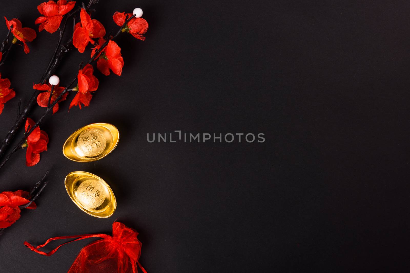 Chinese New Year, flat lay top view, gold bar and Chinese Flower on black background with copy space for your text