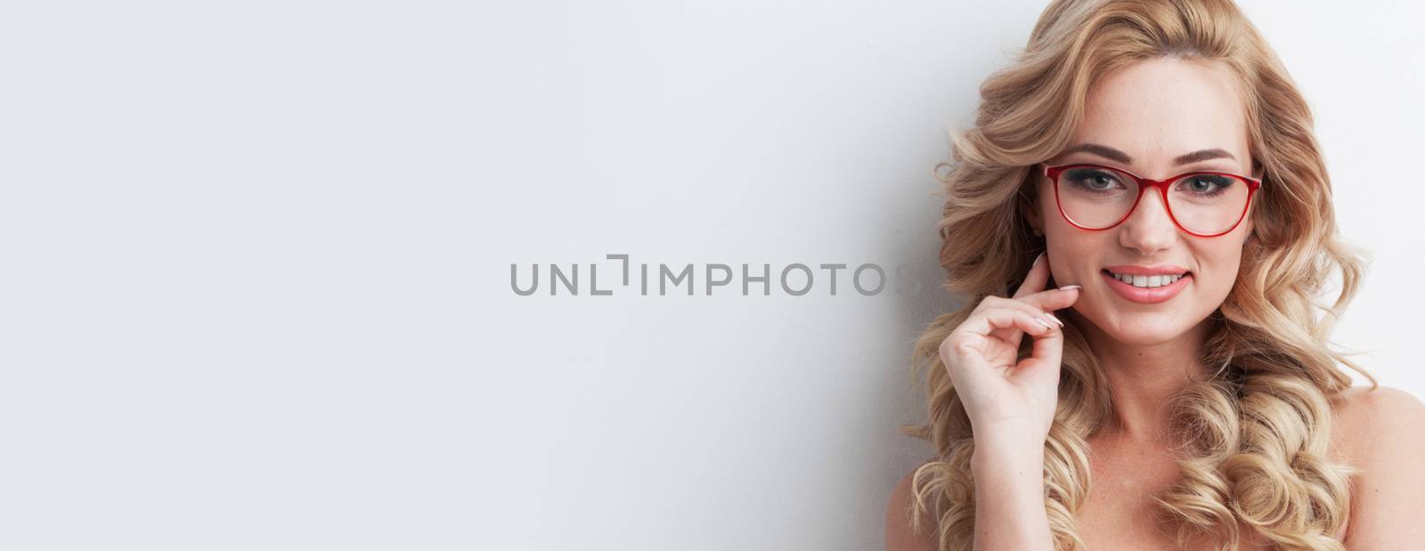 Beautiful young blonde woman put on glasses , white background, copy space for text