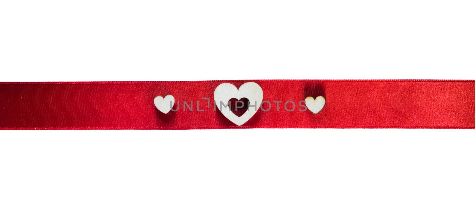 Red satin ribbon with wooden heart shape decor isolated on white background