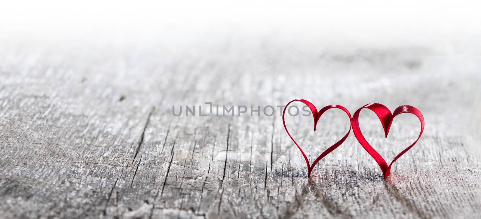 Two red ribbon hearts on wooden background with copy space for text, Valentines day concept