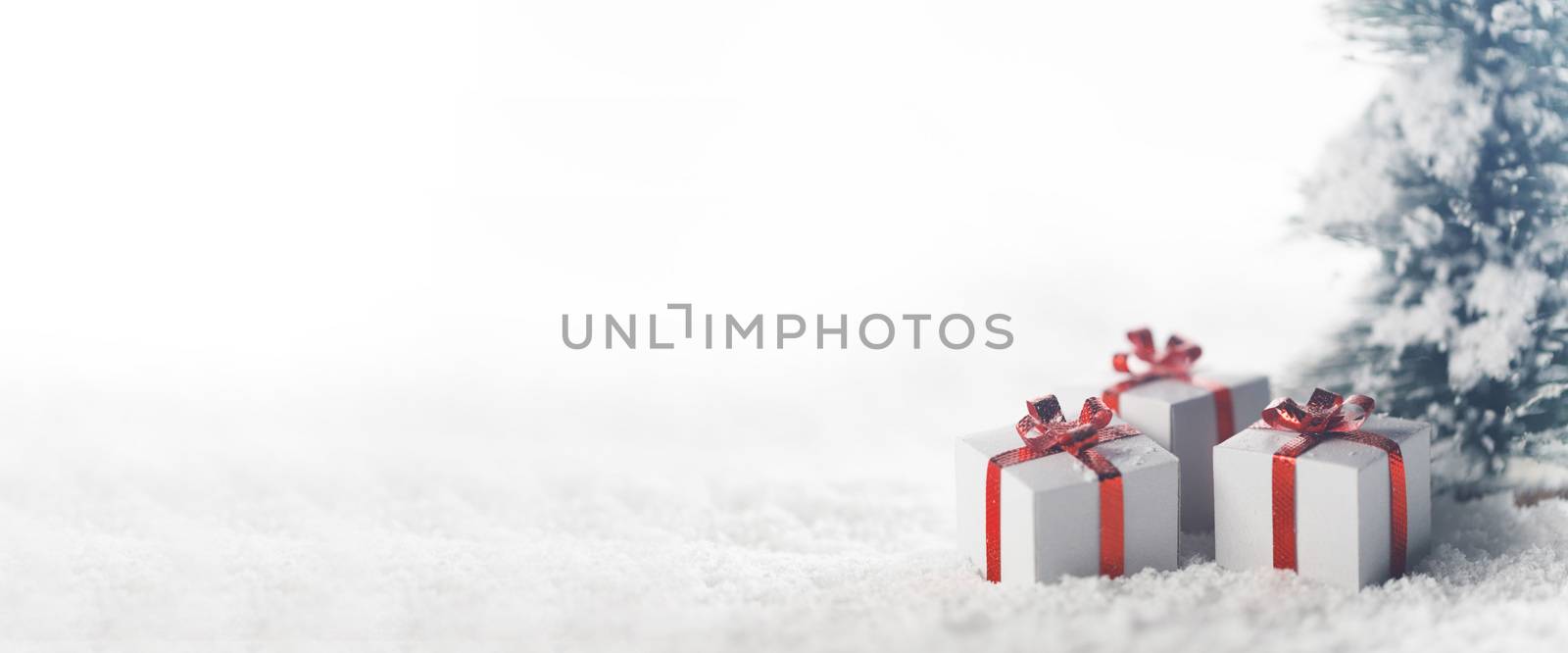 Christmas tree and gift boxes on snow isolated on white background