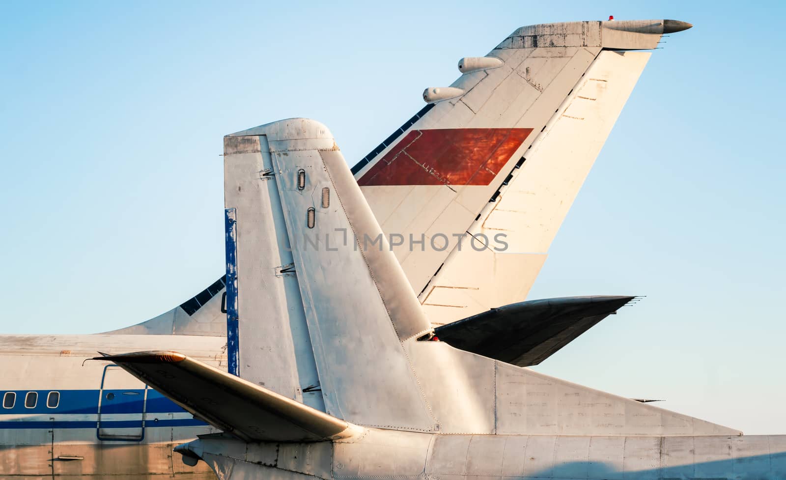 tail and wings of large old airliners with the symbol of the Soviet Union isolated on a blue sky background