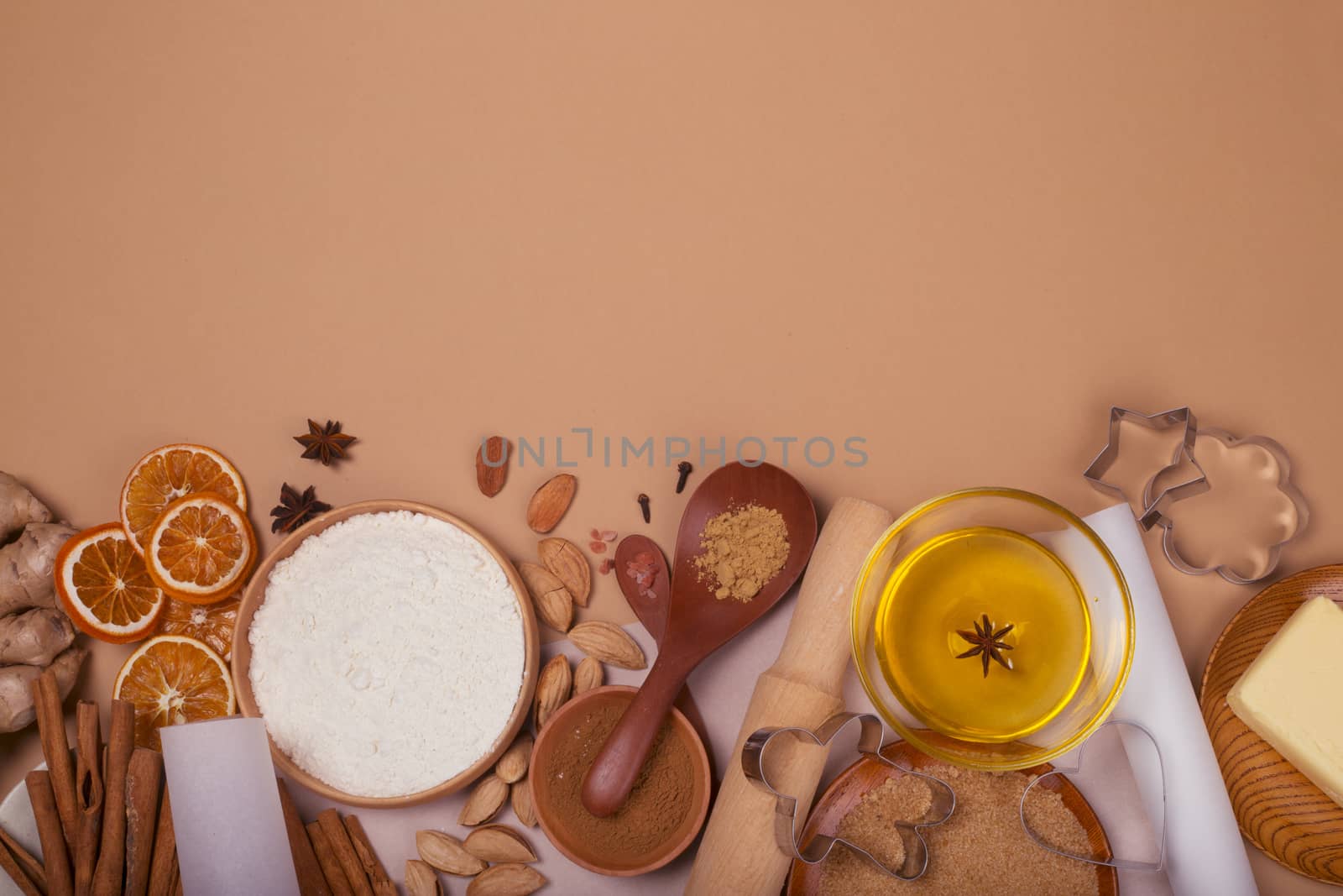 Christmas gingerbread cookies cooking background flat lay top view template with copy space for text. Baking utensils, spices and food ingredients on brown paper background