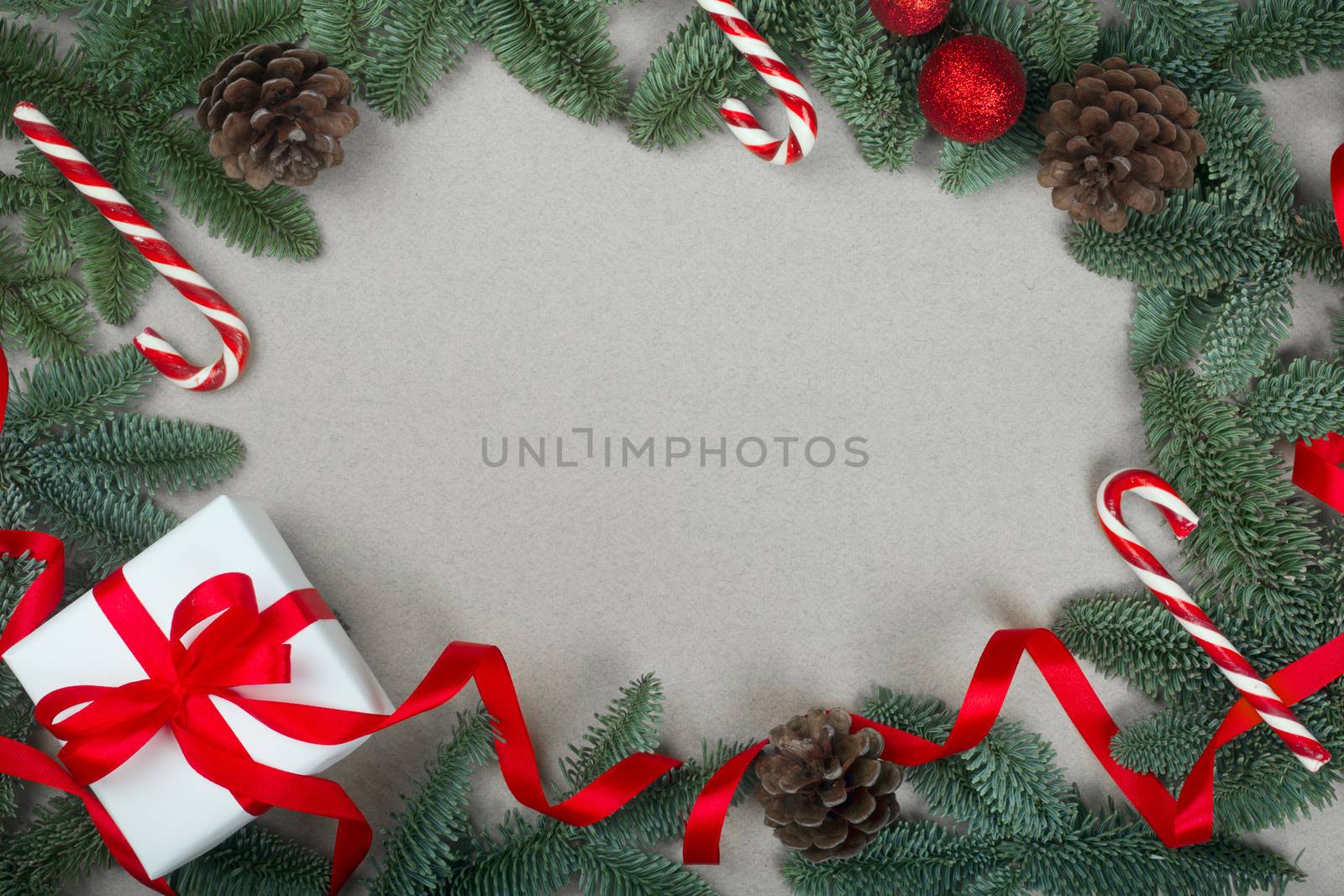 Christmas noble fir tree twigs gift and decorations on brown paper background with copy space for text