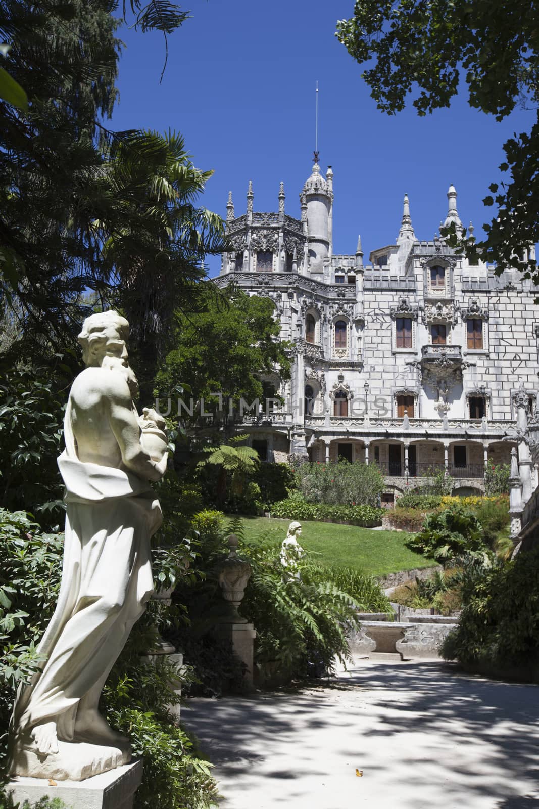 Quinta da Regaleira on  abright sunny day with blooming flowers in front.