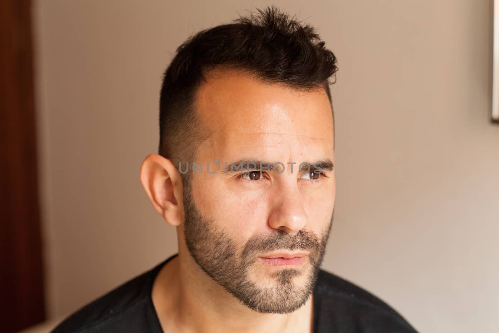 Serious dark-haired man in profile looking aside