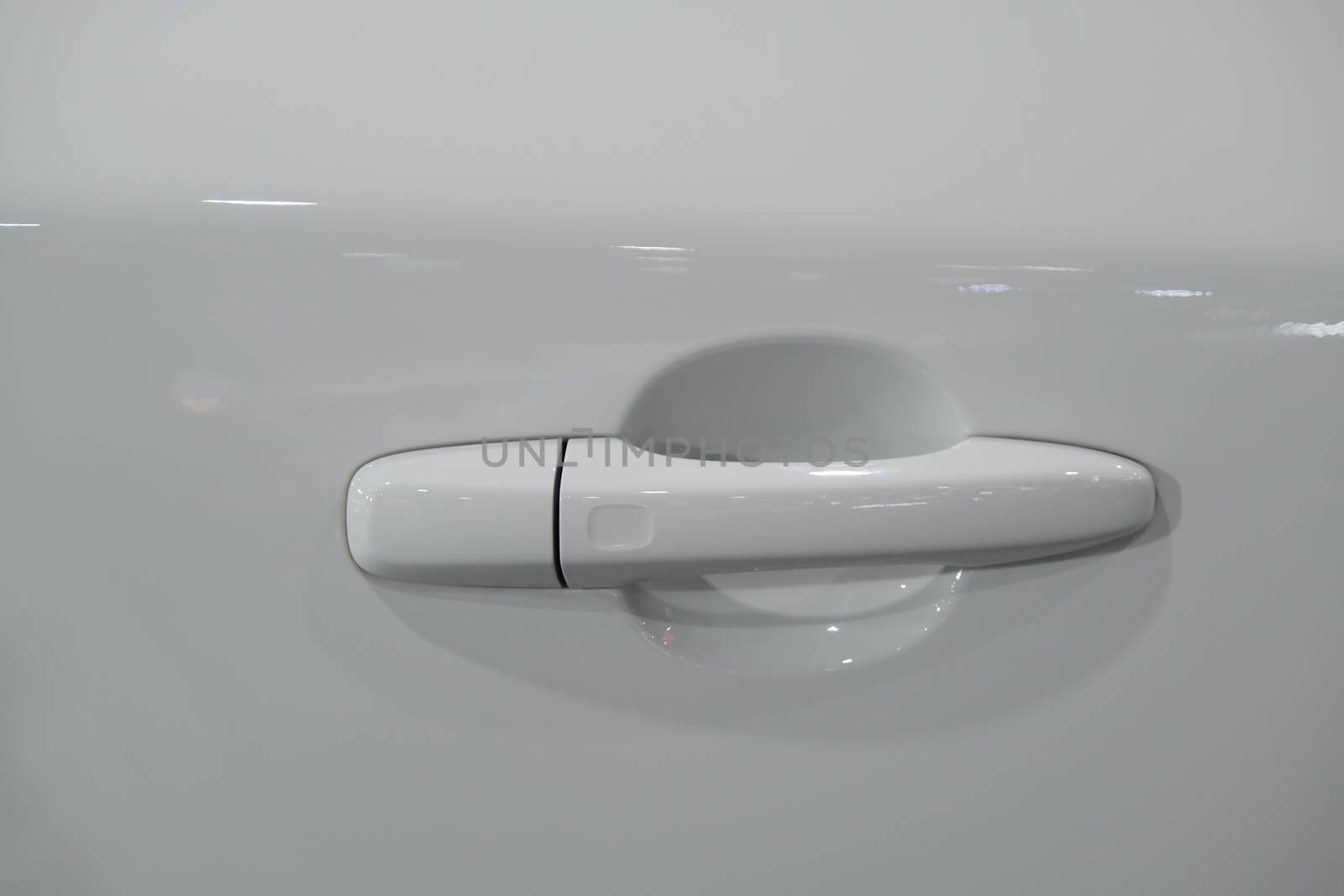Handle of the door of a luxury white car by peerapixs