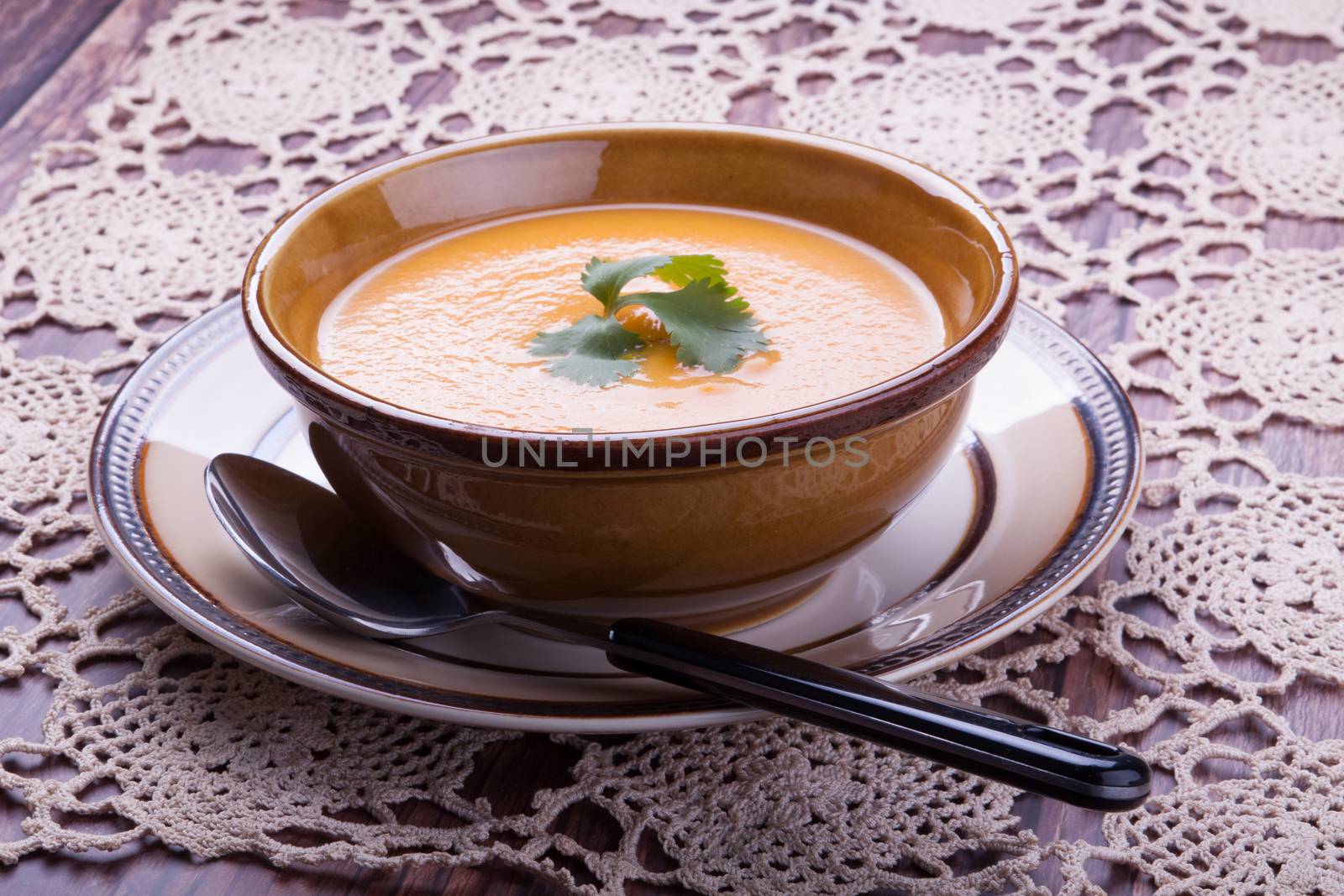 Closeup on a carrot cream-soup with cilantro