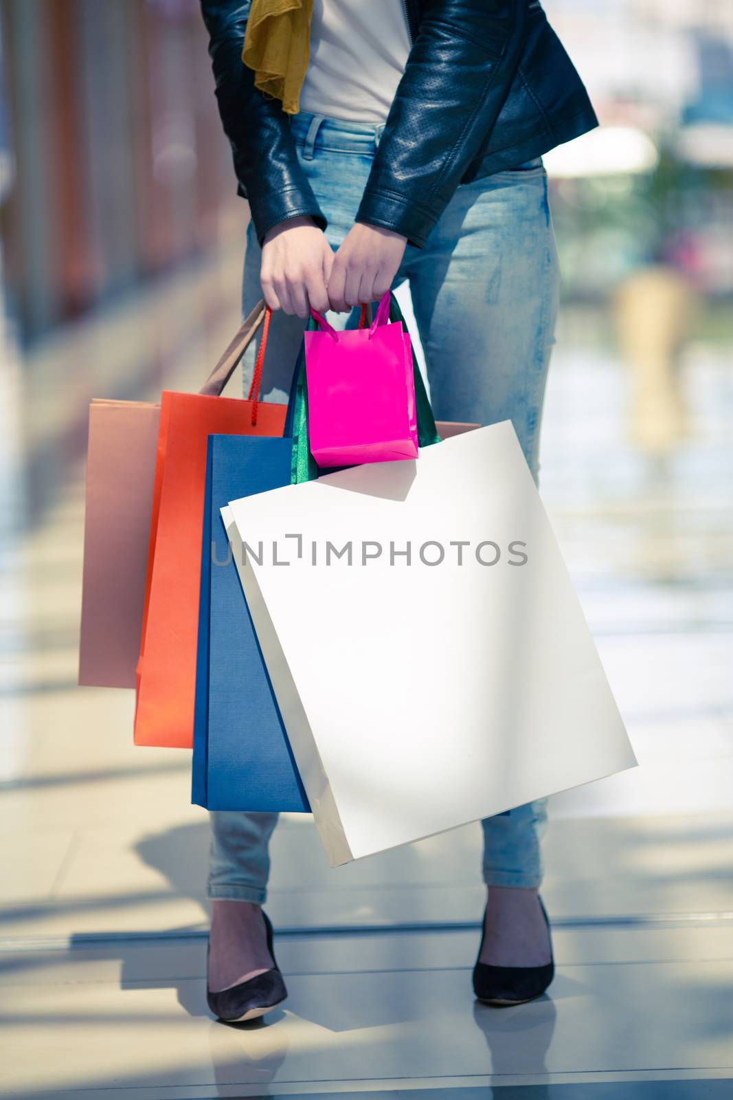 Woman holding many colorful shopping bags sale concept