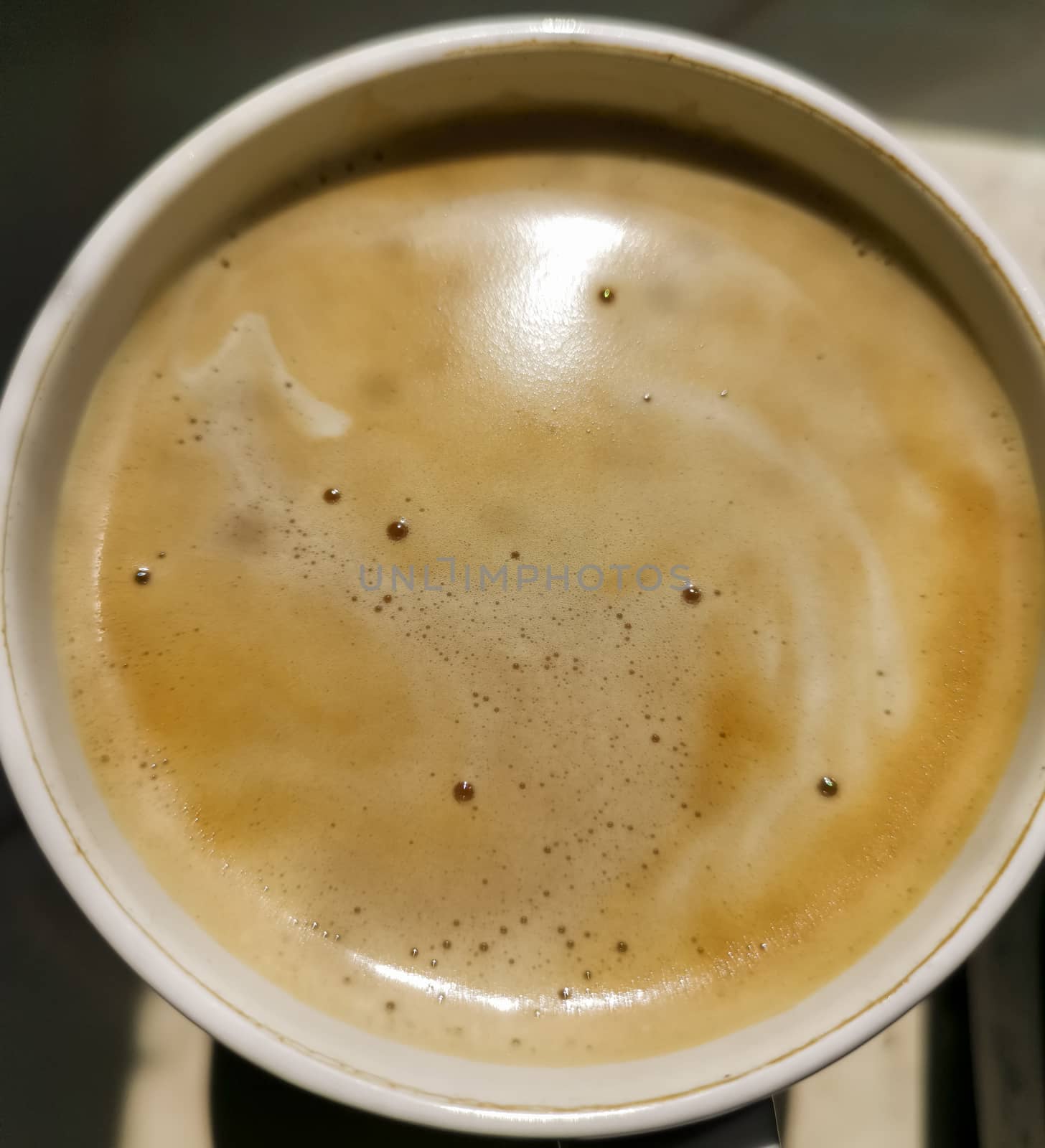 Cappuccino coffee in mug close up. Full cup of latte, mocha with milk froth . macro detail of hot caffeine drink. View from top