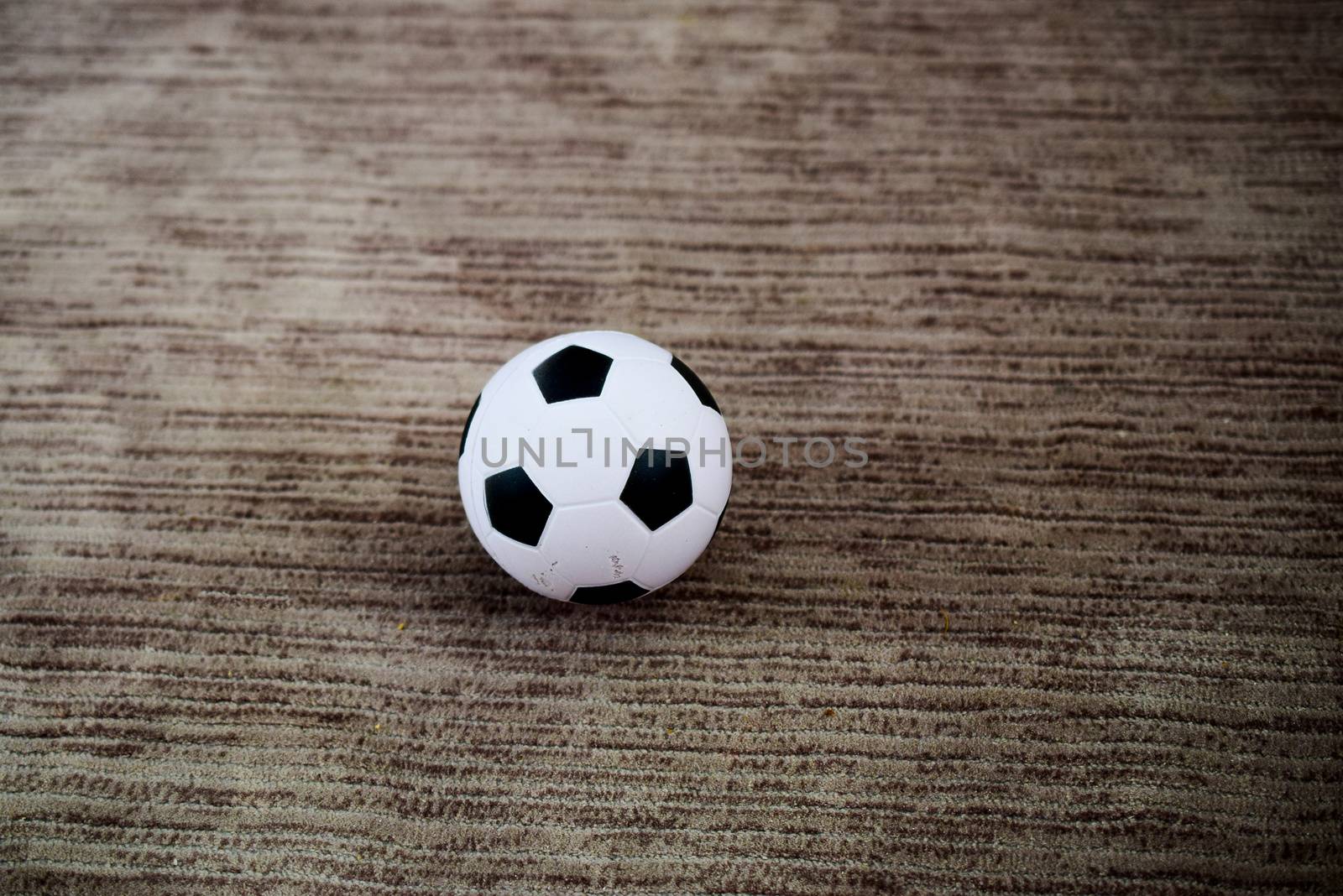 miniature soccer ball on fabric or carpet surface