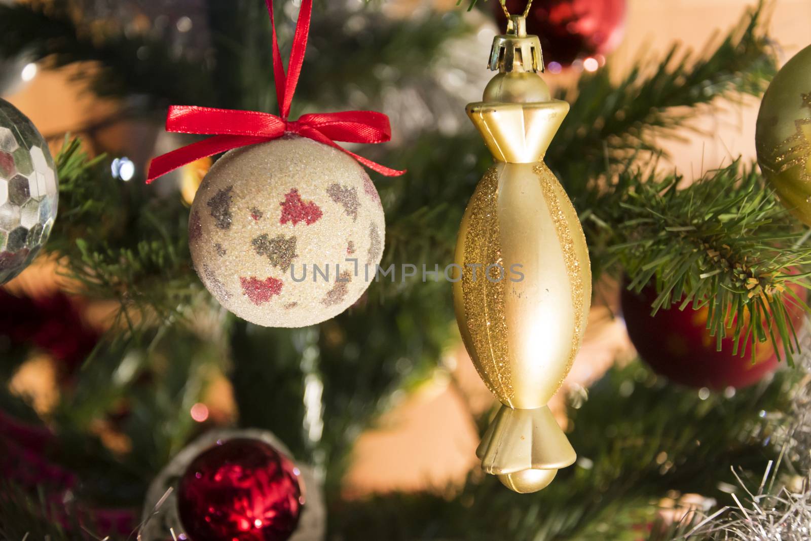 Golden Christmas ornament hanging on Christmas tree. Colorful backgorund. Chrismas and New Year decoration.