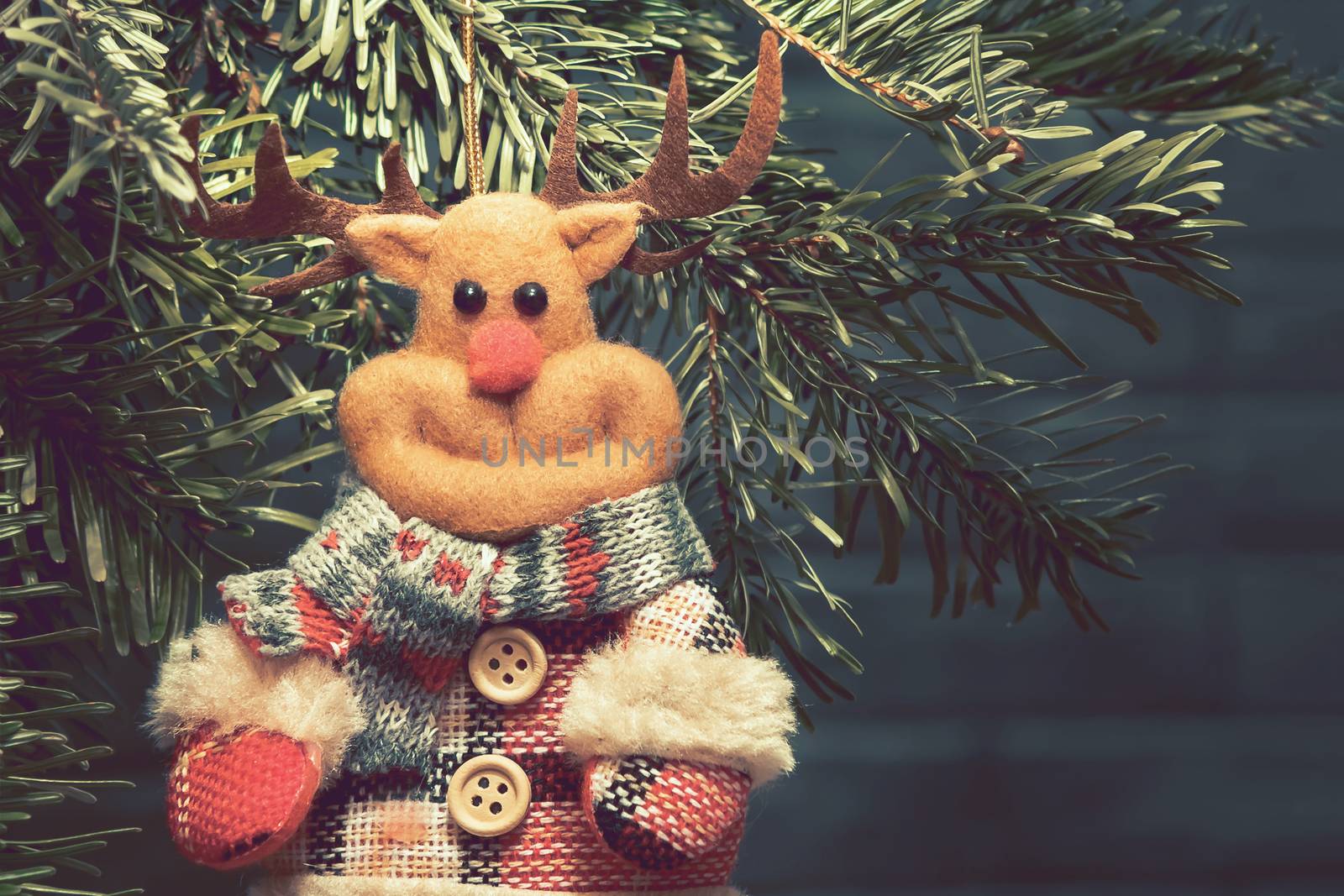 Fabric toy deer on Christmas tree on Christmas eve, place for text, copy space.