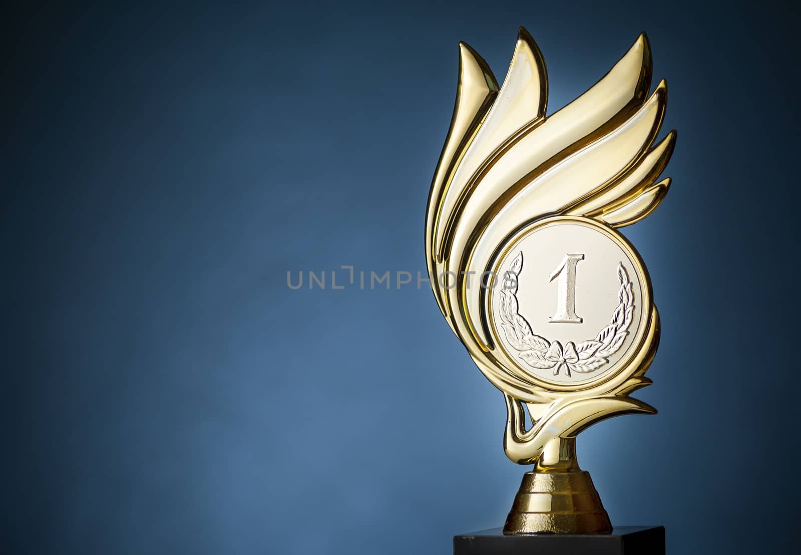 Gold flame style championship trophy for the first place winner over a blue background with copy space