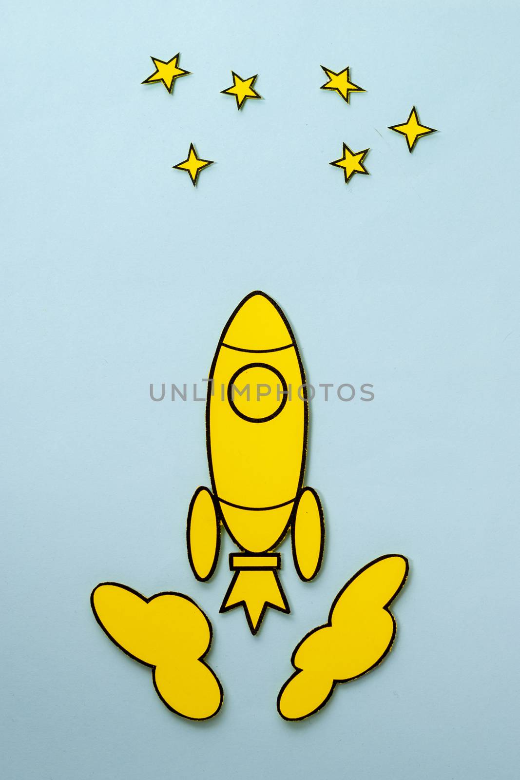 Yellow cartoon rocket flying to the stars zooming through space between the clouds over a blue background with copy space