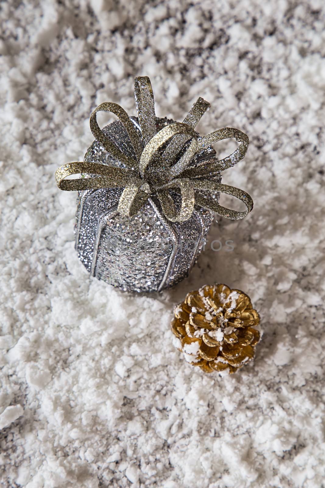 Silver present and gold pince cone in the snow