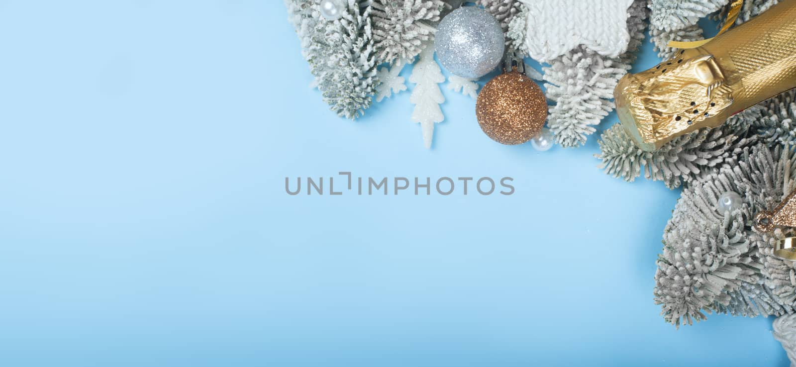 Frosted fir tree twigs and Christmas decorative bauble balls on blue background with copy space for text template flat lay top view design